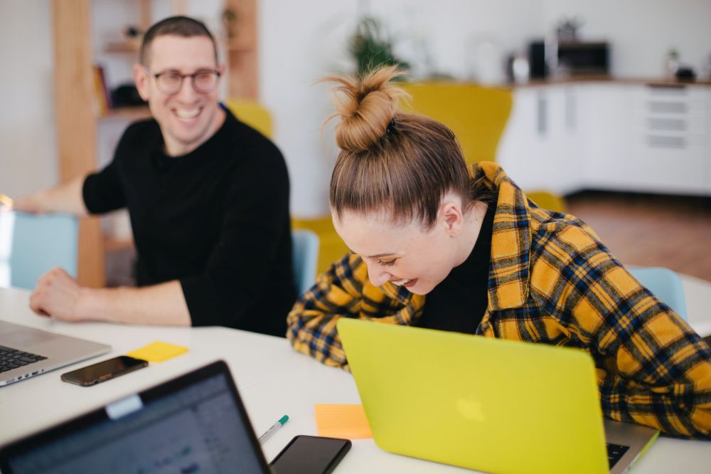 Our employee engagement consultants work with you to create an engaged, healthy and happy workforce, illustrated by two relaxed and smiling employees here.